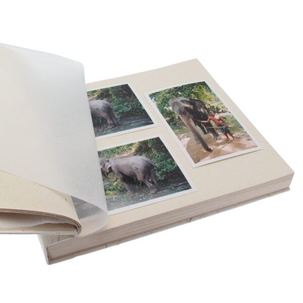 The Elephant Dung Photo Album is open, showing four photos—some with elephants and people—partially covered by a clear protective page.