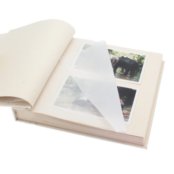 The Elephant Dung Photo Album is open, displaying two pages of elephant photographs that are partially covered by a transparent protective sheet.