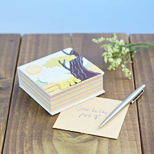 A person has written gone to the pub on a Natural Eco Maximus Elephant Dung Notecube with a sun, tree and elephant design by Paper High.