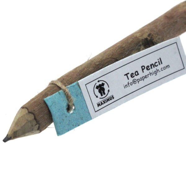 Close-up of a rustic "Tea Pencil," included in the Colourful Elephant Dung Letter Writing Set, with contact info and blue paper tag attached.