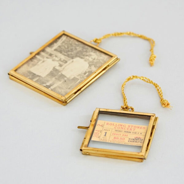 A gold picture frame inscribed with an old black-and-white photo is displayed alongside an Alia Square Glass Hanging Photo Frame containing a Rolling Stones concert ticket from July 1, priced at $8.50.