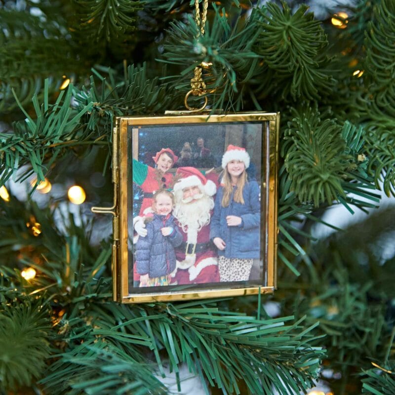 Square Glass Hanging Photo Frame on a Christmas tree featuring a photo of three children posing with a person dressed as Santa Claus.