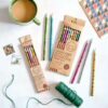 A set of Paper High recycled newspaper pencils and a cup of coffee.