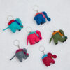 Six vibrant Felt Elephant Keyrings rest on a light backdrop, each crafted in a unique color and embellished with decorative details. These adorable accessories bring charm to any collection.