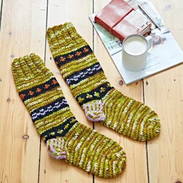 A pair of Woollen Fuji Socks on a wooden floor.
