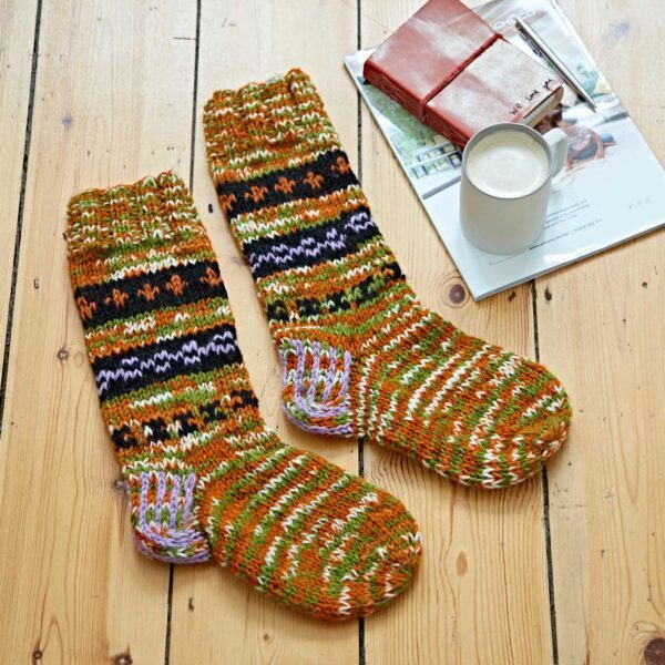 A pair of Woollen Fuji Socks on a wooden floor.