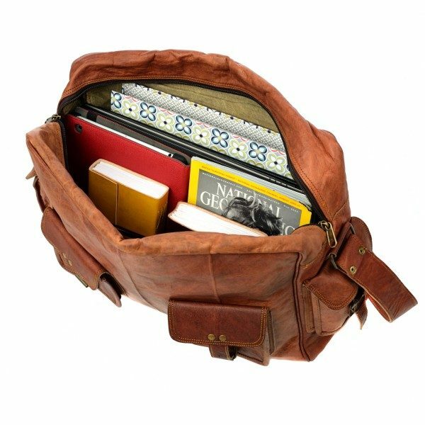Open Personalised Brown Leather Satchel Style Courier Bag containing books, a National Geographic magazine, a notebook, and a patterned folder, viewed from above.