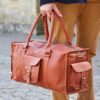 A man is holding a stylish Crossbody Bag.
