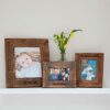 Three Personalised Natural Mango Wood Photo Frames with flowers on a shelf.