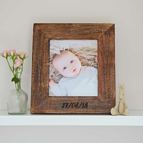 A Personalised Natural Mango Wood Photo Frame displayed on a shelf.