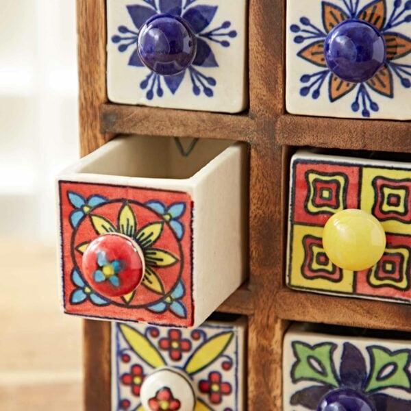 A Multicoloured Mango Wood 6 Drawer Jewellery Box with six small drawers, each featuring colorful, decorative tile patterns. One drawer is slightly open, revealing a flower design with a red knob. Perfect as a jewellery box for your treasured pieces.