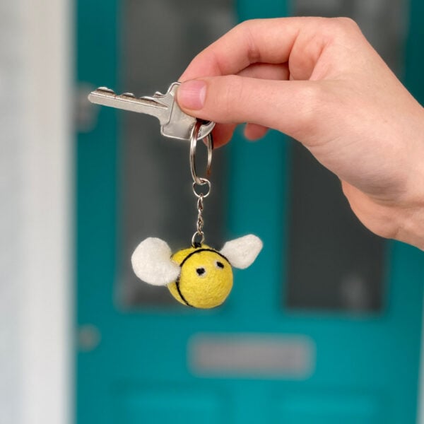 A person holding a Felt Bee Keyring.