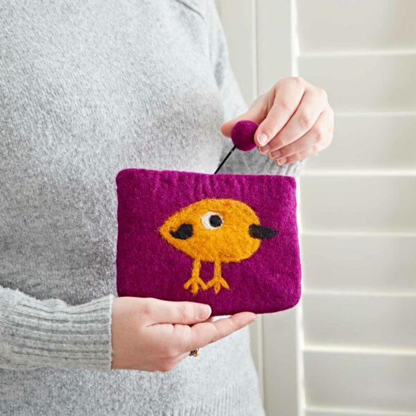 A person holding a Felt Bird Purse is pulling a ball-shaped zipper.