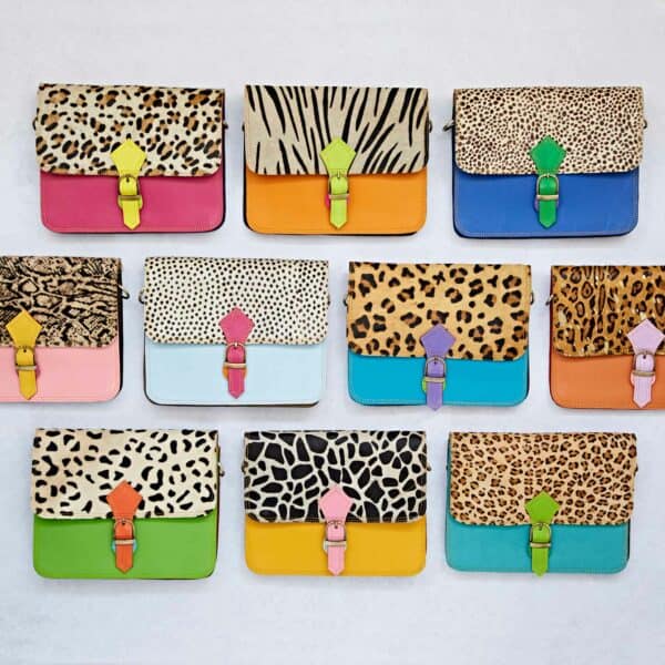 A selection of Multicoloured Crossbody Buckle Bags showcasing vibrant animal prints is laid out in a grid on a light background.