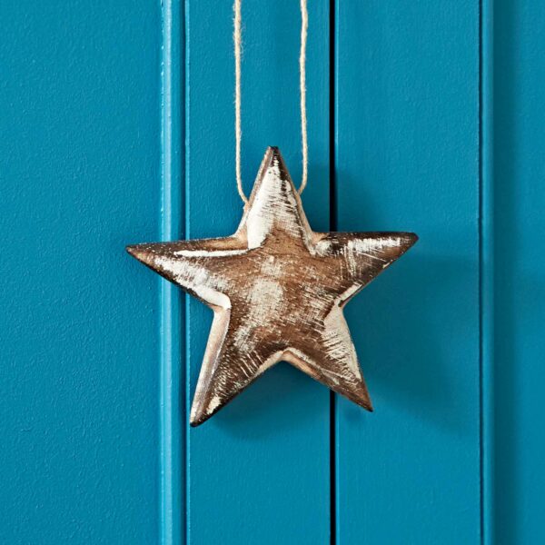 A rustic Mango Wood Heart and Star Decoration hangs on a piece of twine against a bright blue wooden background.