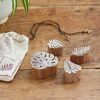 Four Assorted Leaf Design Wooden Printing Blocks, featuring carved leaf motifs and a drawstring pouch, are displayed on a wooden surface.