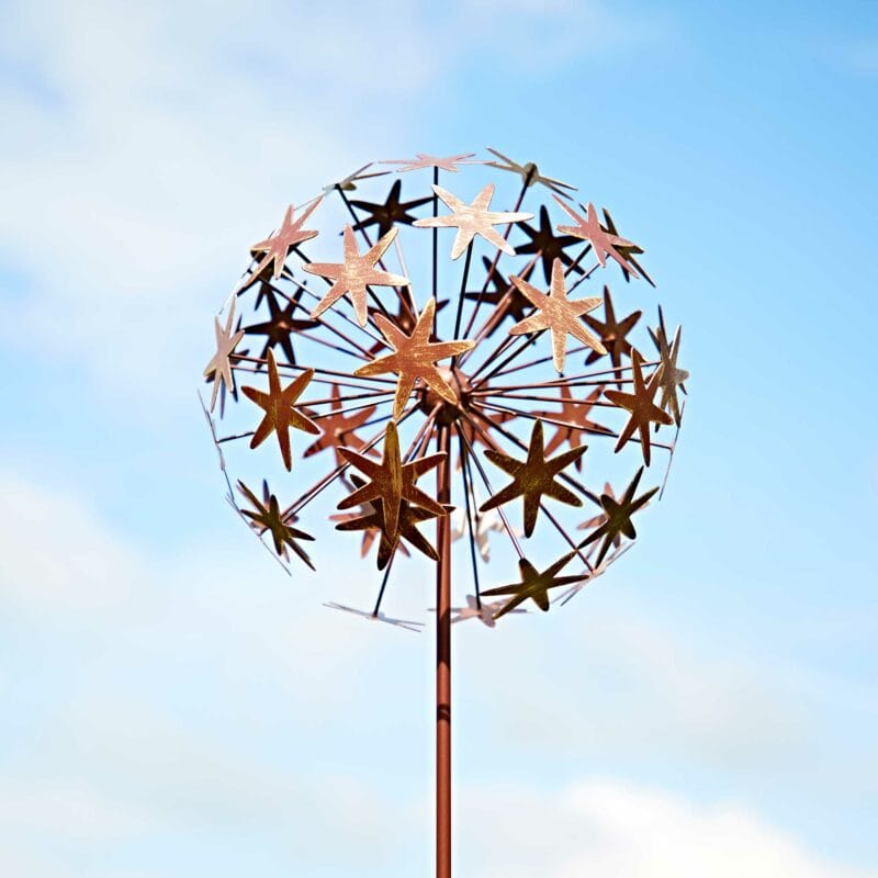 a Metal Allium Flower Garden Stake Decoration against a blue sky.