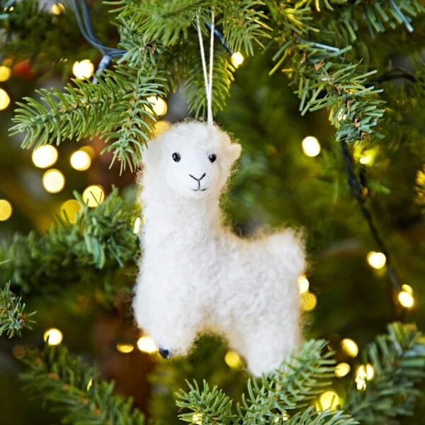 A white Felt Alpaca Christmas Decoration hanging from a tree.