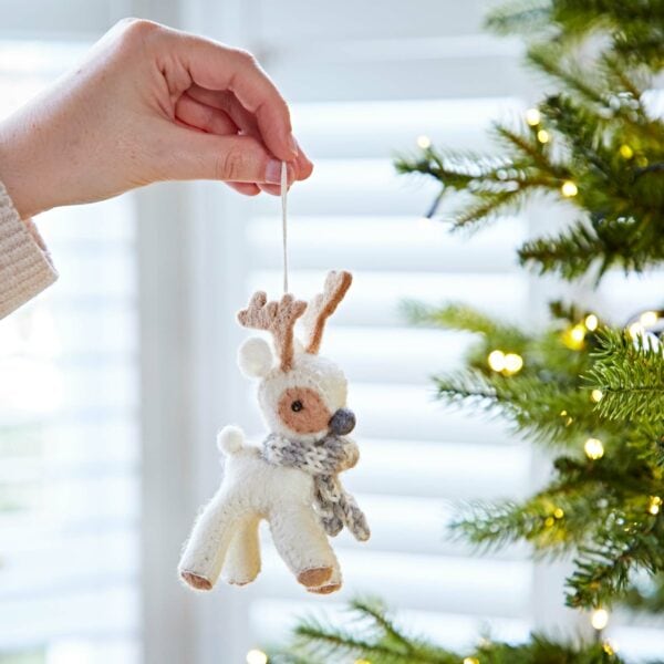 A person holding a Felt Reindeer Christmas Decoration on a tree.