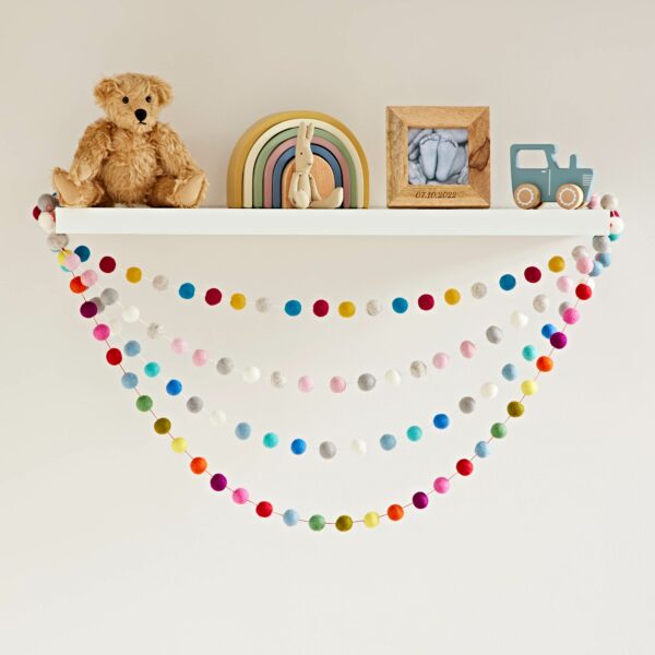 A Handmade Multicoloured Felt Ball Garland adorned with a teddy bear.