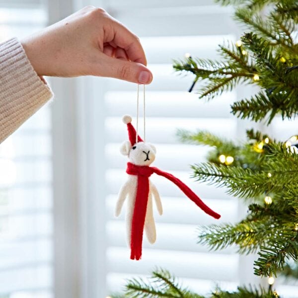 A person holding a Felt Christmas Mouse Decoration on a Christmas tree.