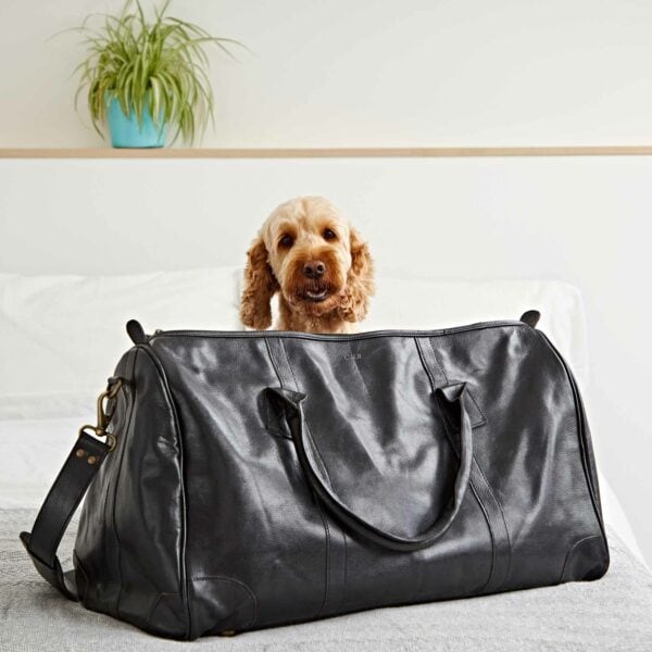 A Customized Black Leather Weekend Holdall with a dog.