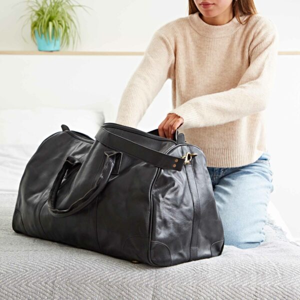 A woman posing with a Personalised Brown Leather Duffle Bag.