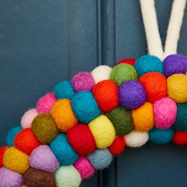 The Felt Multicoloured Wreath stands out brilliantly against a dark blue background.