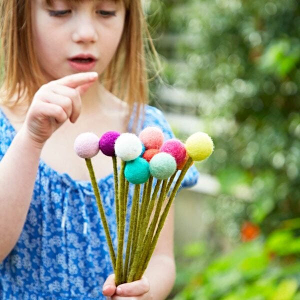 A little girl holding a Pack of 6 Felt Handmade Flower Bouquet.