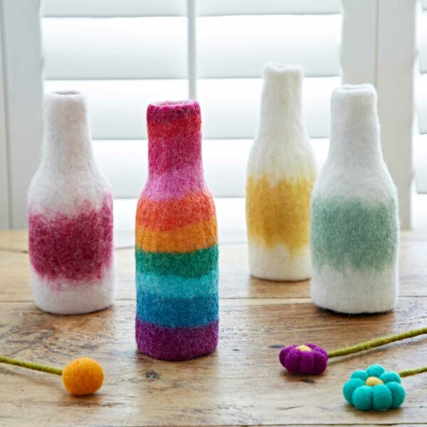 A group of Felt Handmade Colourful Vase Covers on a wooden table.