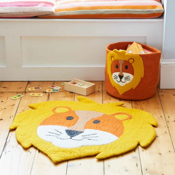 A Felt Handmade Kids Lion Rug and Storage Basket on the floor.