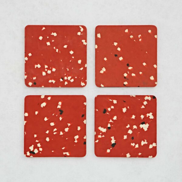 Set of 4 Recycled Plastic red Square Coasters, with black and white spots on them.