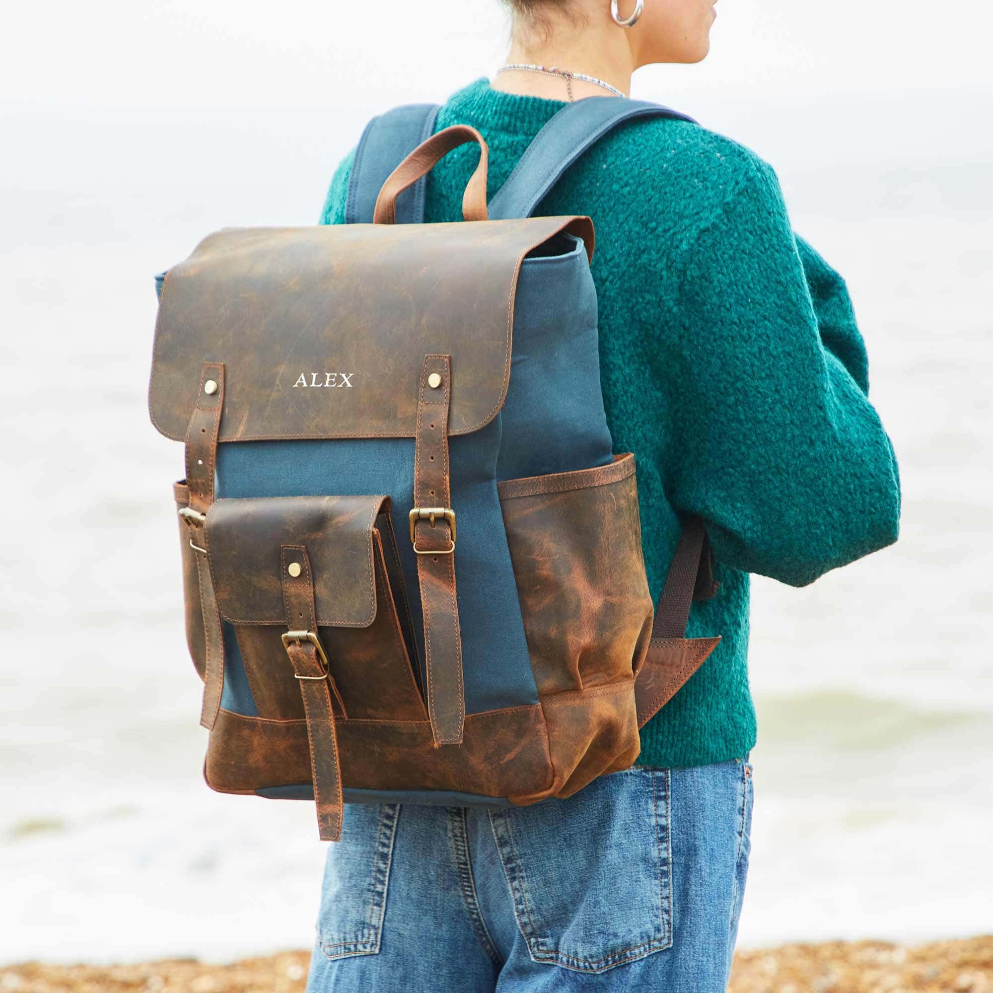 A woman wearing a Personalised Blue Canvas And Buffalo Leather Backpack.