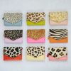Nine Ananya Multicoloured Recycled Leather Purses, each with different animal print patterns and vibrant bases, are arranged in a 3x3 grid on a light background.
