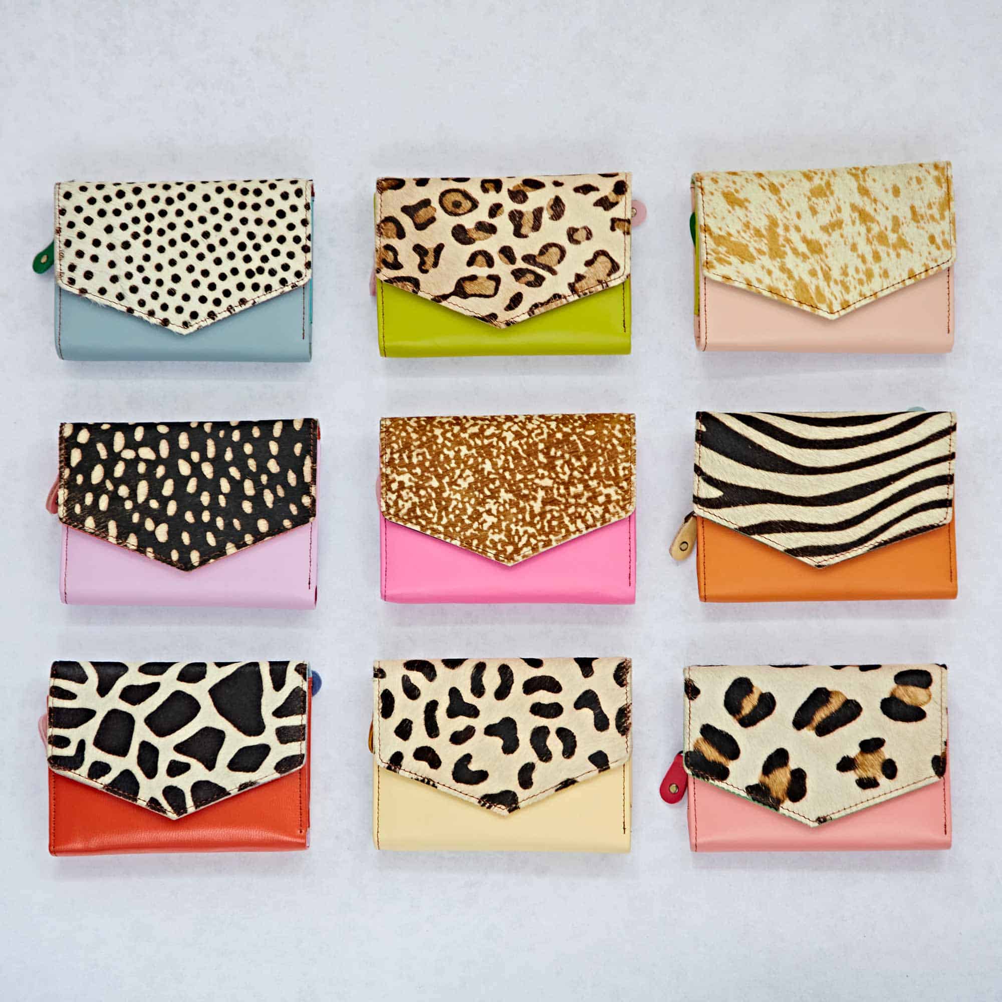 Nine Ananya Multicoloured Recycled Leather Purses, each with different animal print patterns and vibrant bases, are arranged in a 3x3 grid on a light background.