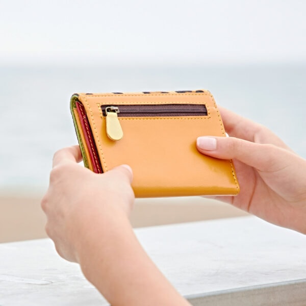 Ananya, a woman with an Ananya Multi-Coloured Recycled Leather Purse, enjoys the beach.