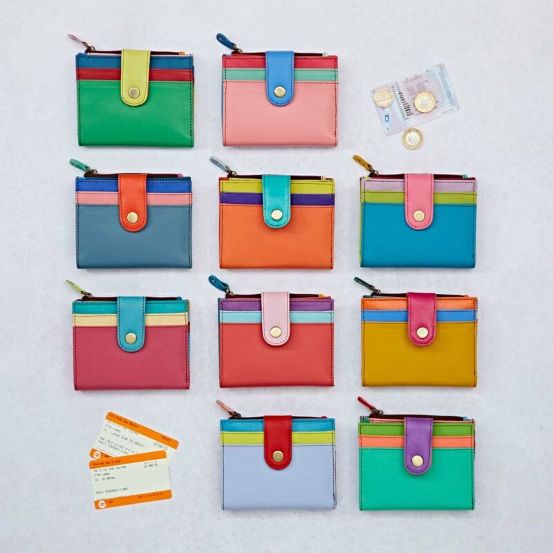 A grid of ten colorful wallets, featuring the Personalised Iman Recycled Leather Small Purse, two bus tickets, a credit card, and coins are arranged on a light surface.