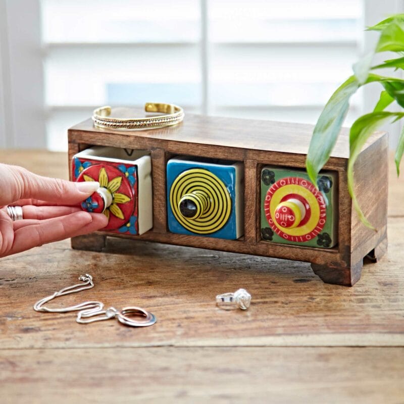 A person is holding a jewelry box on a table.