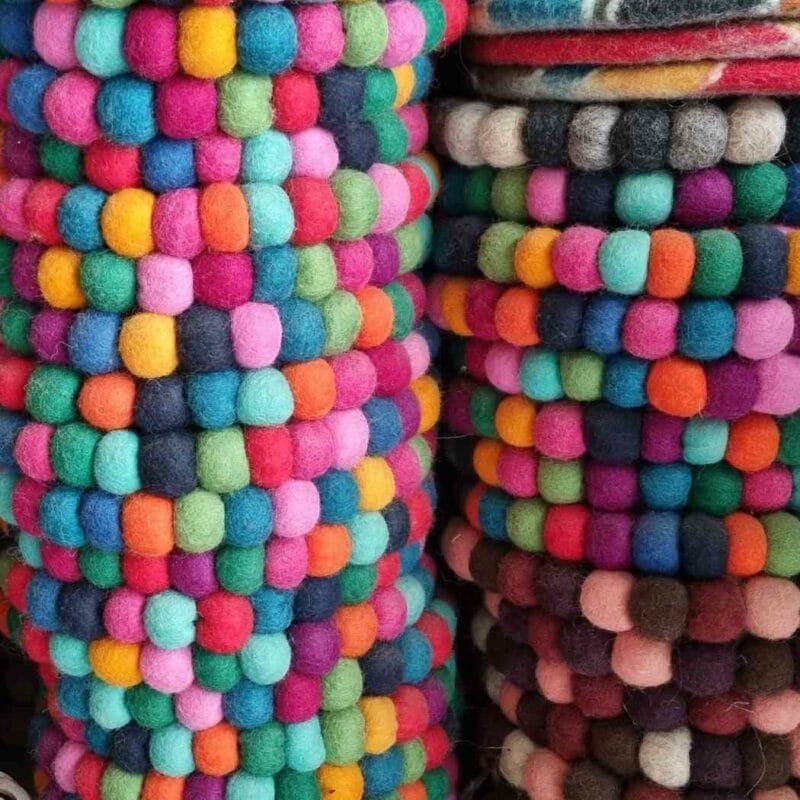 Colorful felt balls stacked on top of each other with a care guide.