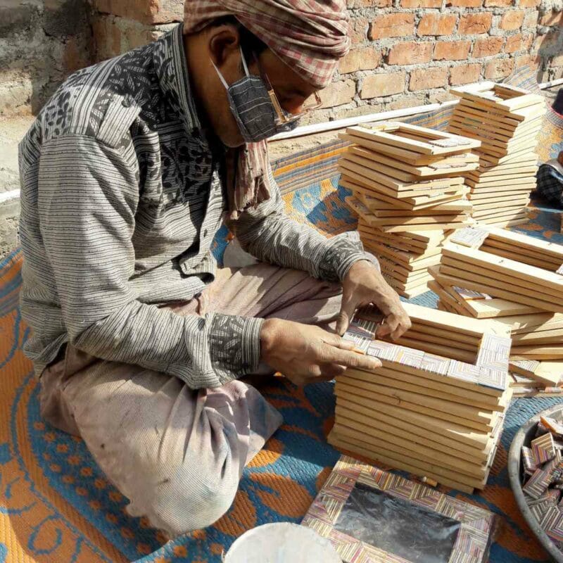 A man is working on a wooden frame with a care guide.