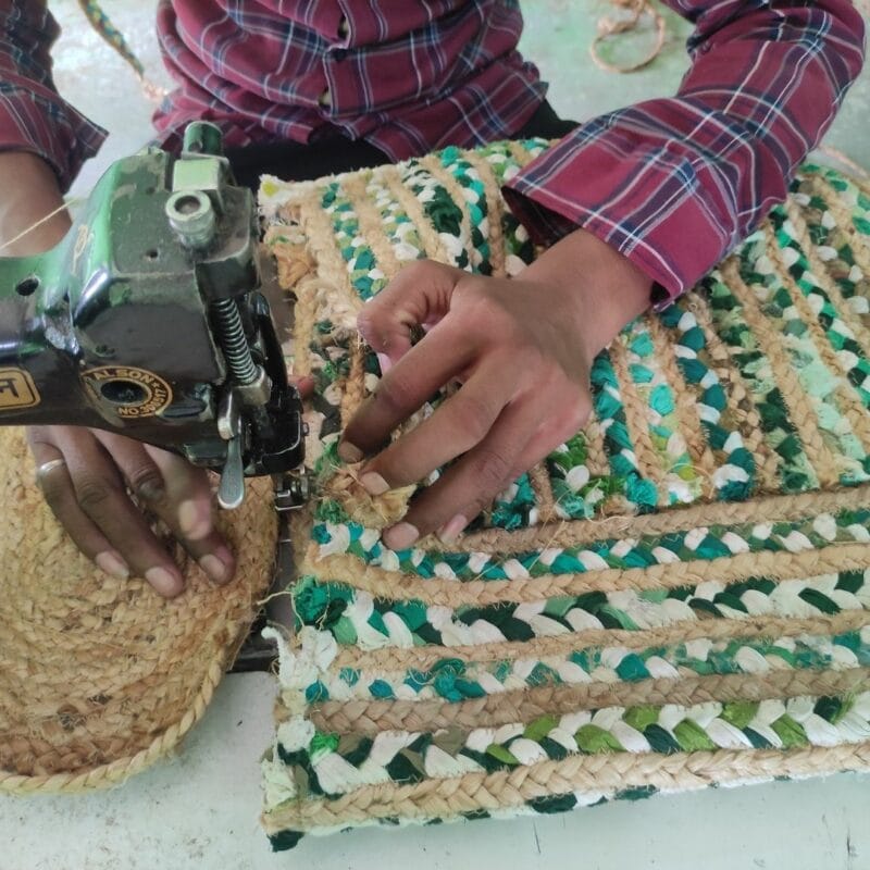 A man is sewing a rug with a sewing machine according to the care guide.