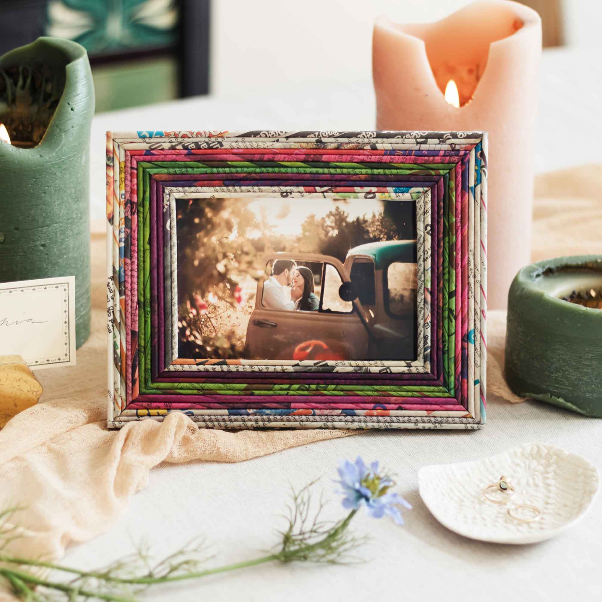 A colorful picture frame on a table displaying a photo of a couple in a car, surrounded by candles and decorative items, destined as a Mother's Day gift.