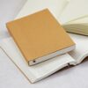 Four open notebooks with Lined and Plain Paper for Refillable Journal, including one brown-covered refillable journal in the center.