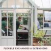 A person in a green shirt working at a table inside a greenhouse, visible through open doors, with plants surrounding the workspace. Text below reads "FLEXIBLE EXCHANGES & EXTENSIONS." This scene could be straight out of the Half Day The Edible Garden Course at The Raymond Blanc Gardening School, Le Manoir aux Quat Saisons.
