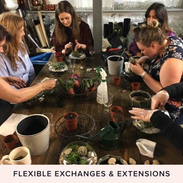 A group of people sitting around a table engaged in the Moyses Stevens Classic Hand-Tied Bouquet Workshop for Two, with various gardening tools, pots, and plants on the table. Text below reads "Flexible Exchanges & Extensions".
