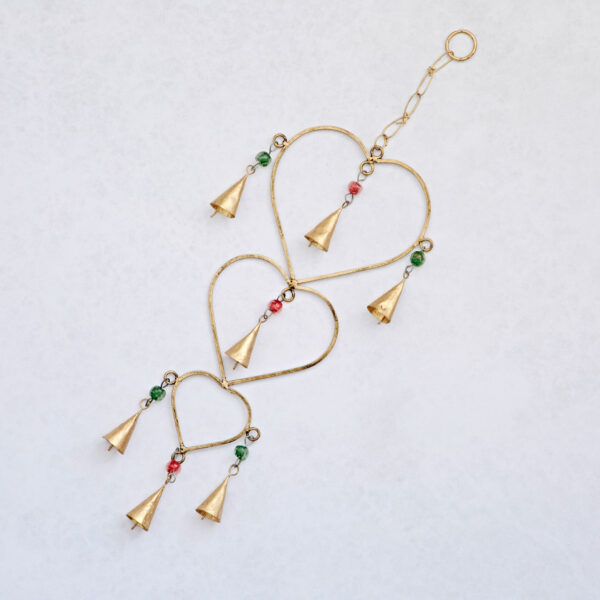 The Recycled Iron Heart and Bells Wind Chime features three gold-tone hearts with green and red beads and cone-shaped bells. Crafted from recycled iron, it adds charm with its colorful accents and gentle chime sounds.