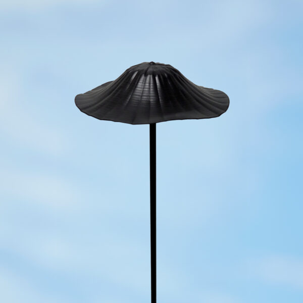 A striking Recycled Metal Mushroom Garden Stake, featuring a black wide-brim top on a thin pole, stands against a blue sky—perfect for adding unique, eco-friendly flair to your garden décor.
