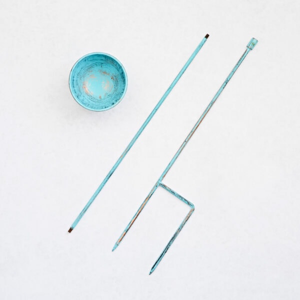 The Recycled Iron Distressed Blue Rain Catcher features a weathered blue metal bowl and three recycled iron rods, one bent at a right angle, arranged on a white background.