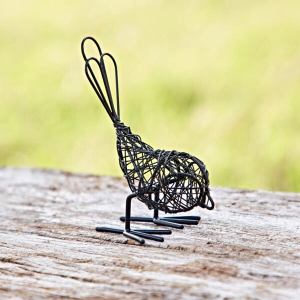 A Set of Two Wire Robins with looped tails and delicate wings decorates a wooden surface against a blurred green background.