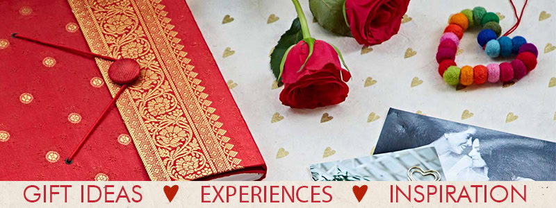 A red gift box with gold embroidery, two roses, a colorful bracelet, and a black-and-white photo atop a heart-patterned surface. Text reads: Gift Ideas for Parents, Valentine's Day Inspiration. Perfect for creating the ideal banner this season.
